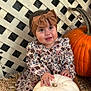baby, child, pumpkin, white_pumpkin, orange_pumpkin, bow_headband, floral_dress, straw, lattice_fence, fall, autumn, cute, smiling, sitting, outdoor, person, headband, baby_shoes, brown_shoes, seasonal