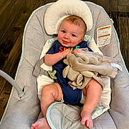 Asher joined the competition — help win amazing prizes! baby, infant, smiling, baby_seat, blanket, pacifier, wooden_floor, clothing, indoor, comfort, cute, face, child, relaxing, soft_toy, legs, head_support, happy, person, cushion