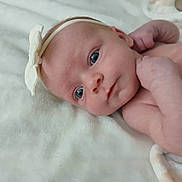 Callie is registered to the contest to win money with this photo: newborn, baby, infant, portrait, face, eyes, blue_eyes, headband, lying_down, blanket, white_blanket, indoor, close_up, skin, arms, hands, adorable, awake, photography, family