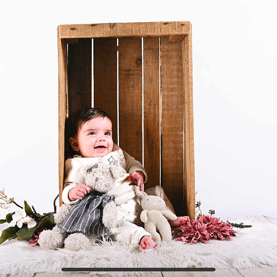 Elena participe au concours pour gagner de l'argent avec cette photo : baby, child, cozy, cute, cute_face, decor, flower, happy, indoor, infant, plush_toy, portrait, sitting, smiling, soft_toy, studio, white_rug, wood_floor, wooden_crate, young_child