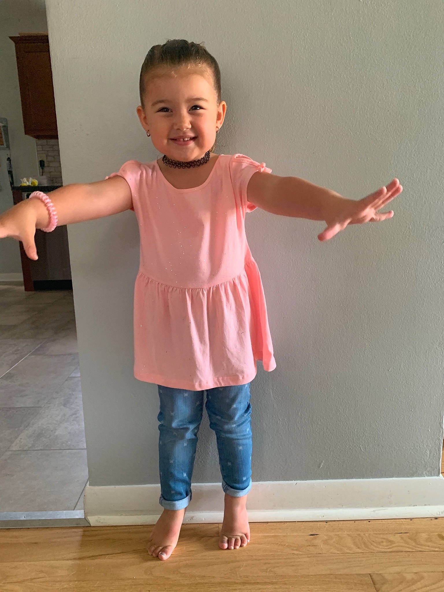 Kinleigh is registered to the contest to win money with this photo: arm, child, finger, floor, footwear, gesture, hand, human_body, joint, joy, knee, leg, neck, outerwear, person, pink, shoe, shoulder, sleeve, standing
