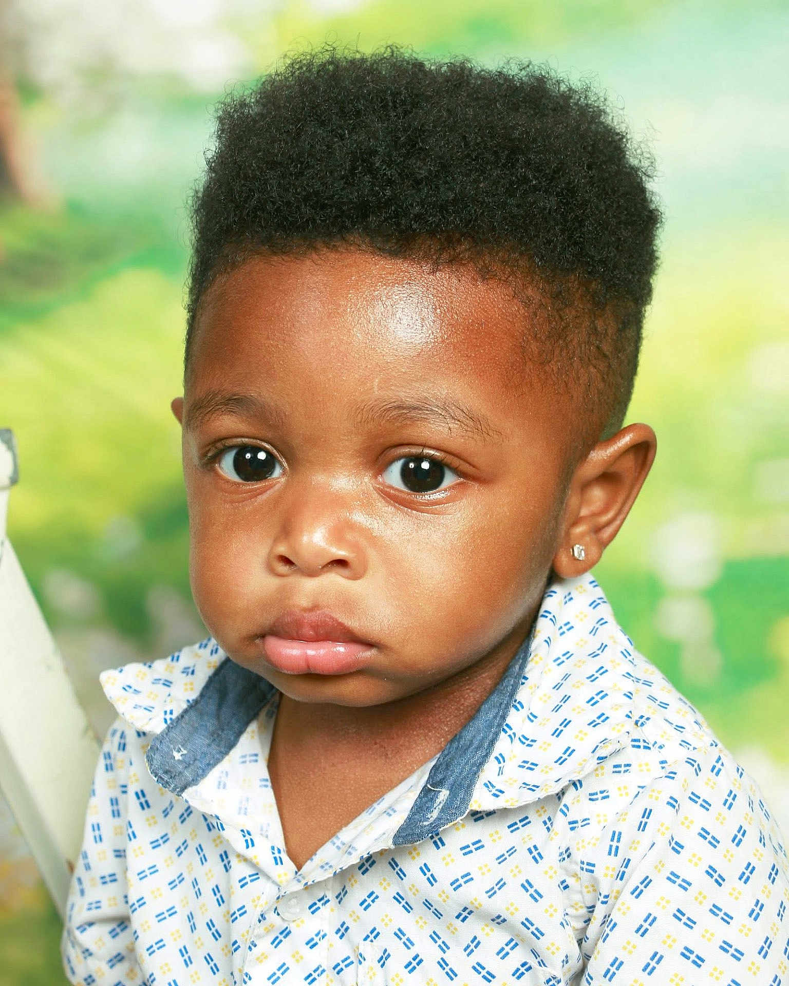 Atreus is registered to the contest to win money with this photo: child, toddler, portrait, face, expression, curly_hair, shirt, earring, indoor, studio, cute, young_child, fashion, person, head_and_shoulders, looking_at_camera, innocence, soft_light, background, closeup