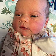 Everleigh Ann Canter joined the competition — help win amazing prizes! baby, infant, face, person, clothing, floral_pattern, onesie, blanket, soft_lighting, closeup, skin, head, eyelashes, cheeks, newborn, sleepwear, cute, indoors, resting, portrait