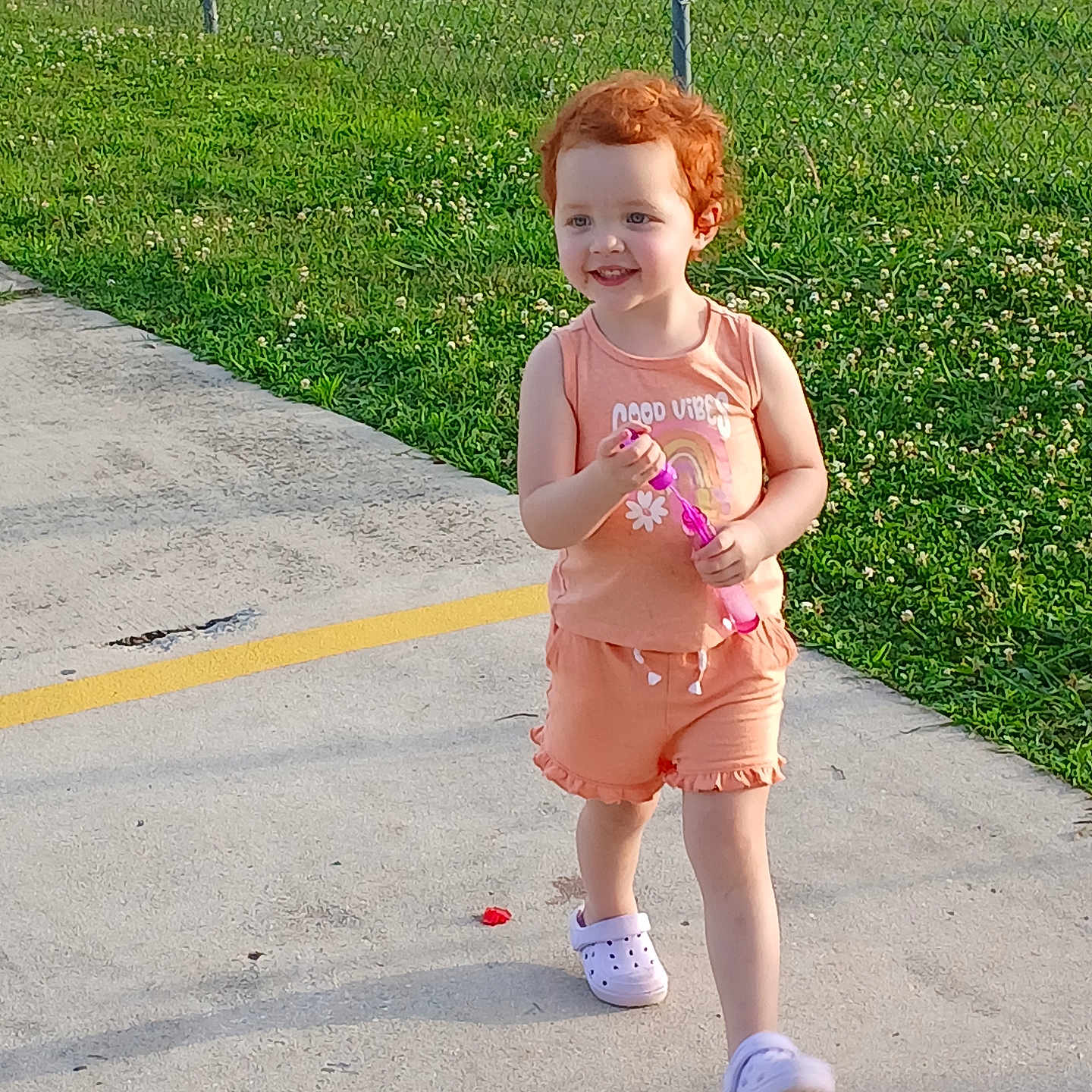 Lexee joined the competition — help win amazing prizes! bubble_wand, casual, child, concrete, curly_hair, daylight, fence, grass, happy, nature, outdoor, person, play, red_hair, smiling, sneakers, summer_clothing, sunlight, toddler, walking