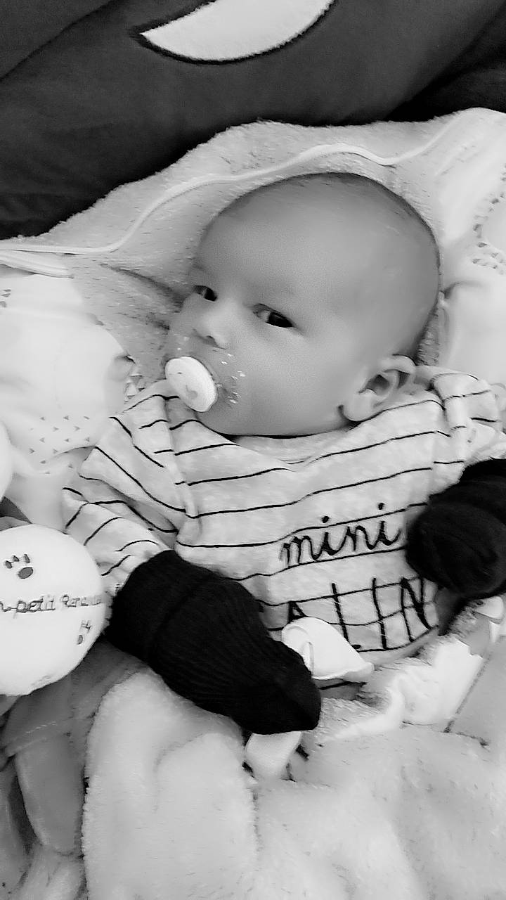 Lyzio a rejoint le concours — aidez-le/la à gagner de superbes lots ! baby, baby_toddler_clothing, black, black_and_white, cheek, child, comfort, facial_expression, flash_photography, happy, human, lip, mammal, monochrome, monochrome_photography, mouth, person, sitting, skin, toddler