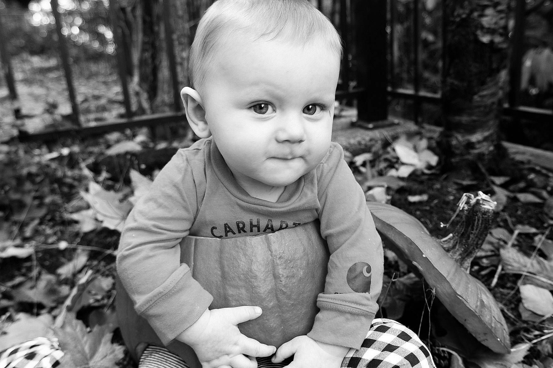 Luke is registered to the contest to win money with this photo: adaptation, black, black_and_white, child, eye, facial_expression, grass, hairstyle, happy, head, human_body, iris, organ, people_in_nature, person, photograph, plant, smile, style, toddler