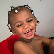 Jaceieon is registered to the contest to win money with this photo: child, smiling, laughing, braids, beads, happy, face, skin, red_cushion, indoor, young, person, hair, cute, teeth, joy, bare_shoulders, expression, portrait, fun