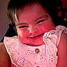 Ariel Rae is registered to the contest to win money with this photo: baby, child, smiling, face, white_dress, buttons, portrait, cute, happy, eyelids, skin, person, infant, indoors, dark_background, closeup, human, cheeks, hair, expression