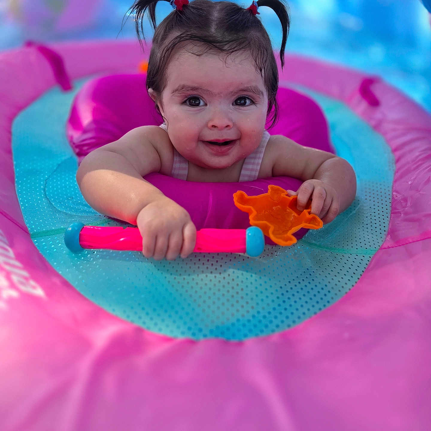 Ariel Rae joined the competition — help win amazing prizes! baby, child, pigtails, inflatable_pool_toy, pink, blue, water, toy, orange_toy, smile, happy, face, portrait, outdoor, summer, play, fun, cute, person, floating