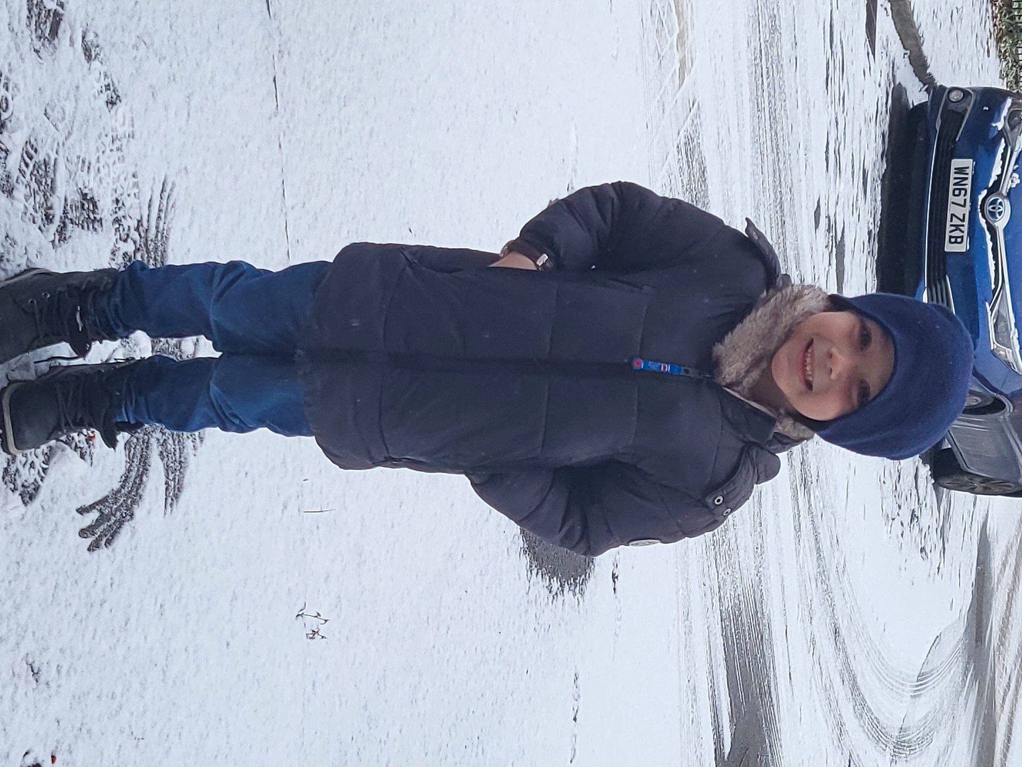 Charlie is registered to the contest to win money with this photo: electric_blue, freezing, fun, geological_phenomenon, glove, hat, headwear, joy, outdoor_shoe, person, recreation, shadow, slope, smile, snow, tree, winter, wood