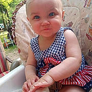 Annastasia joined the competition — help win amazing prizes! baby, child, blue_eyes, high_chair, outdoor, summer, checkered_dress, patriotic, red_white_blue, cute, smirk, cushion, greenery, sunlight, skin, hand, face, person, infant, portrait