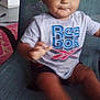 La'Velle joined the competition — help win amazing prizes! toddler, child, sitting, chair, clothing, shirt, logo, indoor, person, face, motion_blur, hand, shorts, furniture, expression, young_child, casual, young, smile, baby