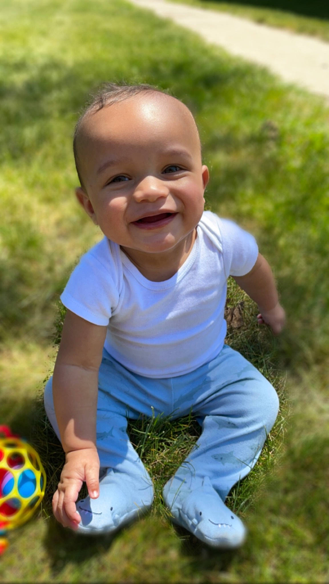 Jakai is registered to the contest to win money with this photo: baby, baby_toddler_clothing, ball, child, face, flash_photography, football, fun, grass, happy, joy, leisure, people_in_nature, person, recreation, sitting, smile, soil, sports_equipment, summer