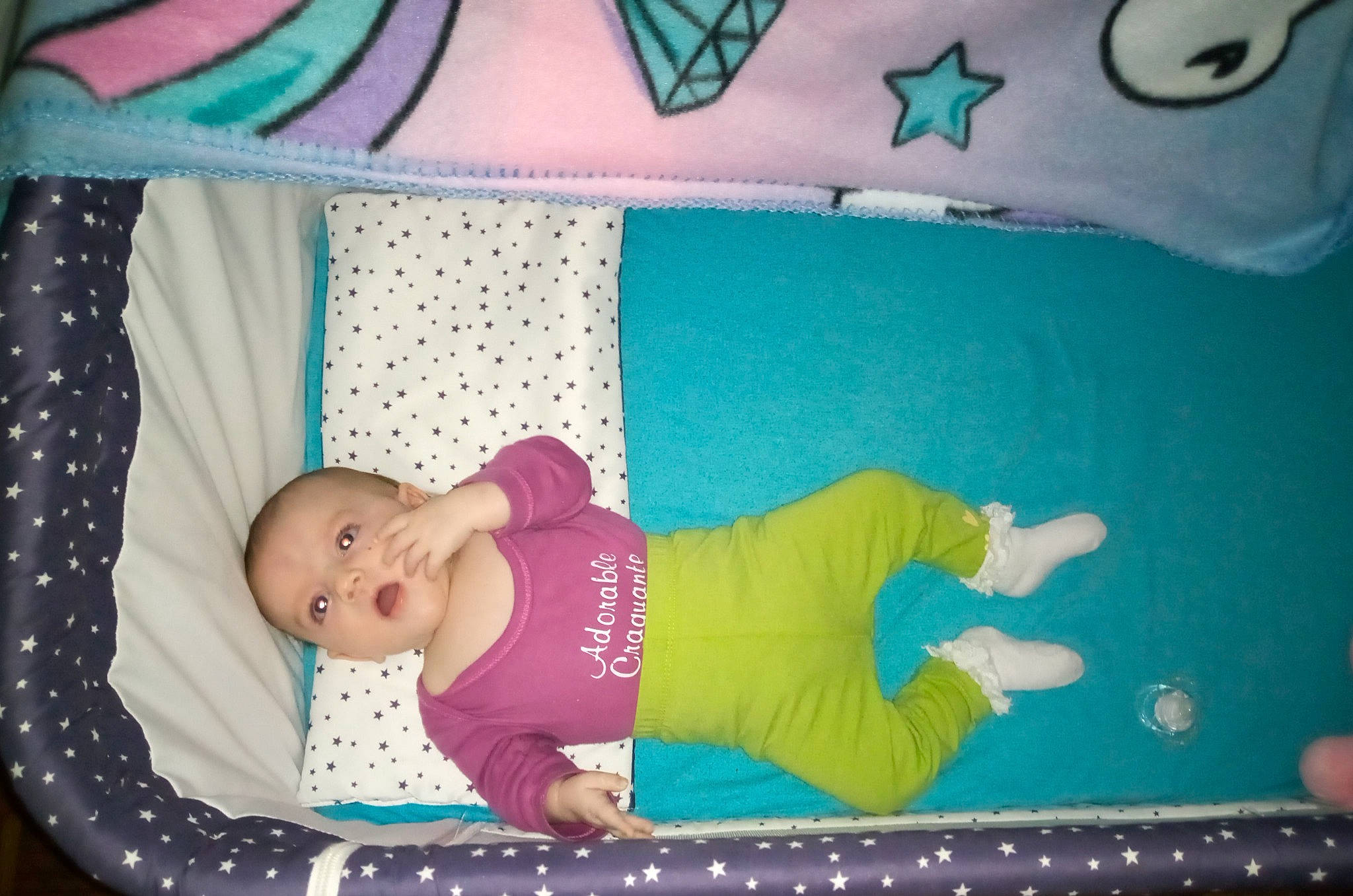 Eva participe au concours pour gagner de l'argent avec cette photo : arm, baby, baby_products, baby_safety, baby_toddler_clothing, blue, child, comfort, face, green, linens, magenta, pattern, person, pink, purple, room, sleeve, textile, toddler