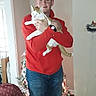 Butterbean joined the competition — help win amazing prizes! brown_furniture, cat, chair, christmas_tree, cozy, doorway, festive, holding_pet, holiday_decorations, home, indoor, jeans, man, pet, red_hoodie, smiling, wall, watch, window, wood_floor