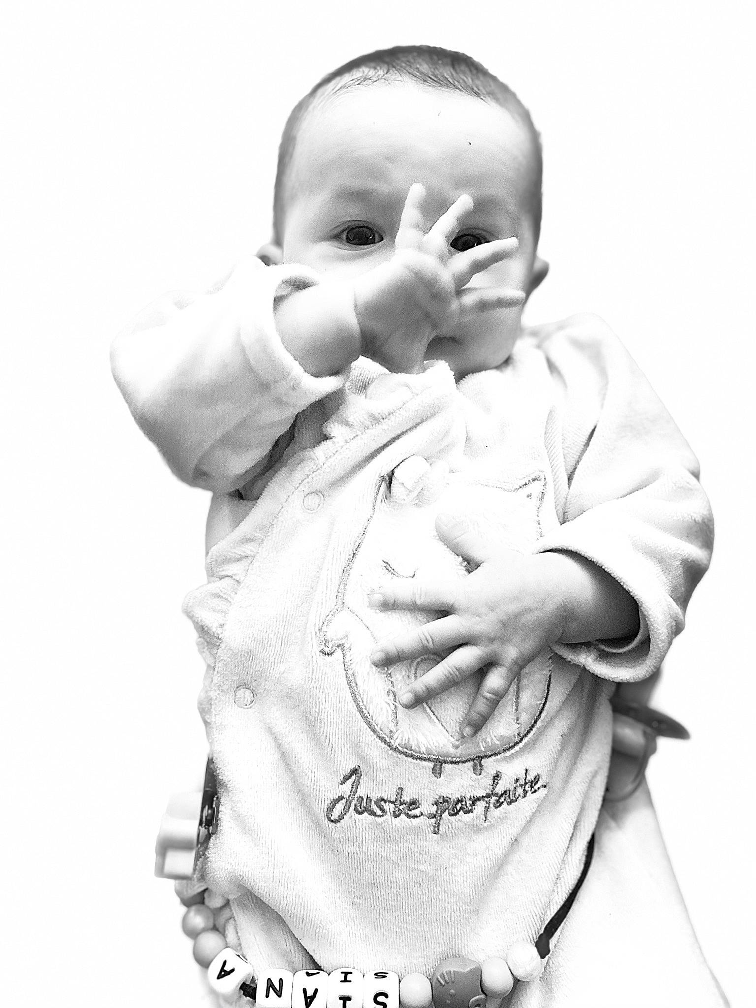 Siana participe au concours pour gagner de l'argent avec cette photo : arm, baby, baby_toddler_clothing, child, drinkware, elbow, finger, flash_photography, gesture, hand, happy, human_body, monochrome, monochrome_photography, neck, outerwear, person, shoulder, sleeve, thumb