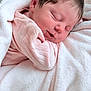 newborn, baby, sleeping, pink_blanket, pink_clothing, soft_texture, close_up, infant, peaceful, resting, cute, child, portrait, indoors, warm, cozy, skin, head, hair, baby_girl