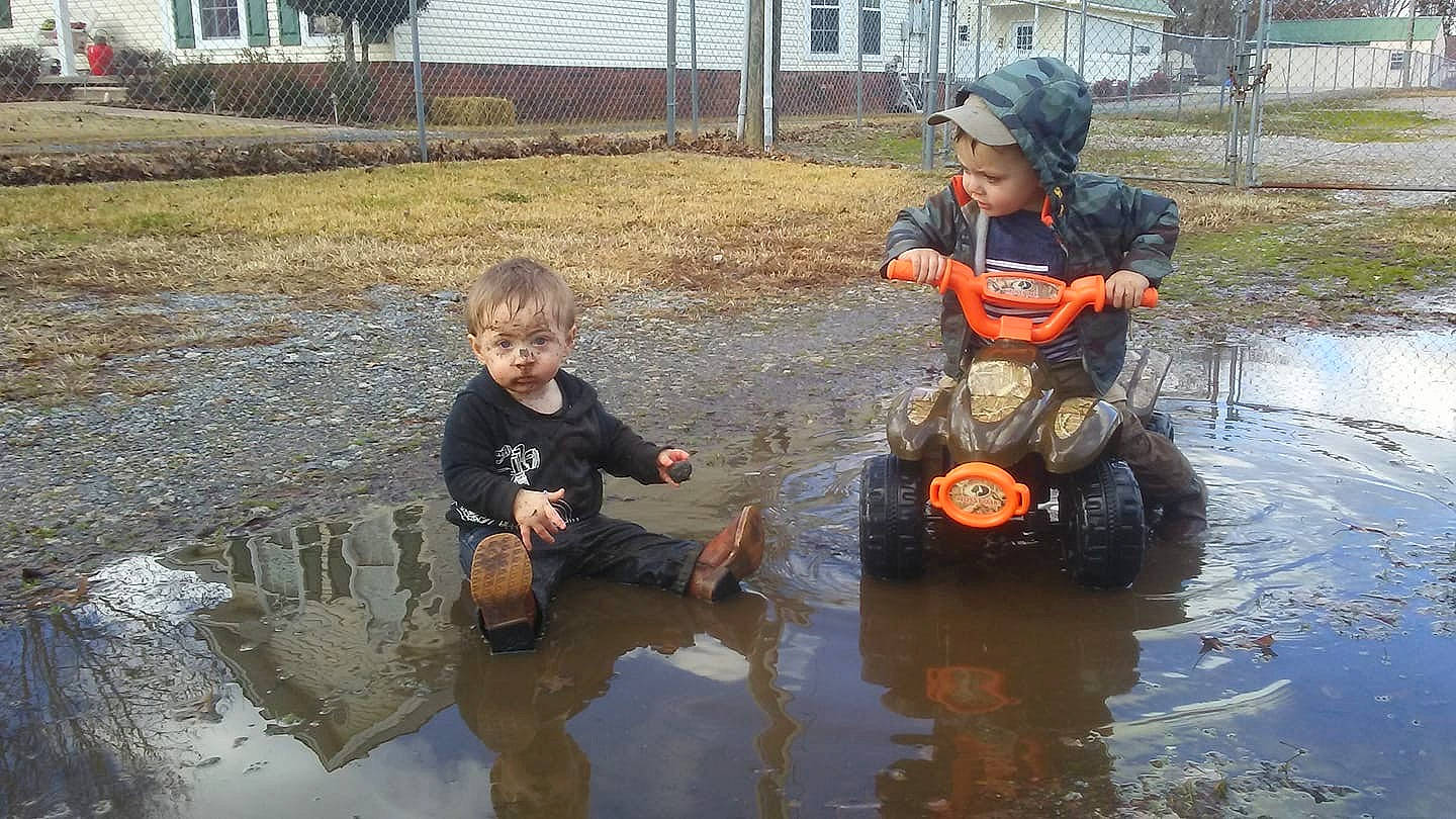 Jackson is registered to the contest to win money with this photo: mud, person, play, puddle, recreation, vehicle, water