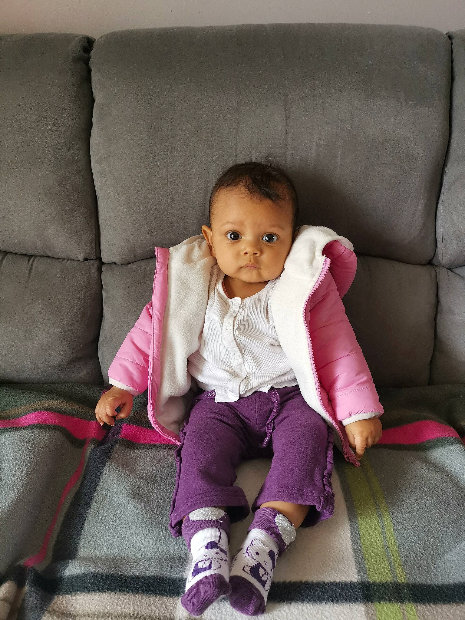 Shana participe au concours pour gagner de l'argent avec cette photo : baby, baby_products, baby_toddler_clothing, cheek, child, comfort, couch, fur, furniture, leg, linens, magenta, pattern, person, pink, purple, sitting, sleeve, sock, throw_pillow