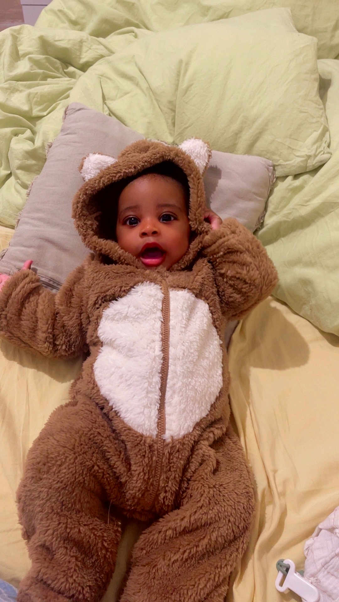 Jaïs participe au concours pour gagner de l'argent avec cette photo : baby, child, infant, costume, bear_suit, hooded, pillow, bed, blanket, soft, cute, smiling, face, person, indoors, warm, fur, eyes, mouth, sleepwear