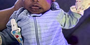 Nora is registered to the contest to win money with this photo: baby, infant, child, onesie, hat, hand, indoor, portrait, closeup, striped_clothing, pacifier_clip, soft_lighting, purple_light, cute, warm, cozy, person, newborn, face, expressive