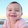 baby, infant, smile, tooth, cheeks, close_up, portrait, beach, ocean, sand, sunset, horizon, towel, onesie, happy, outdoors, young_child, face, portrait_photography, cute