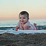 baby, infant, smiling, beach, ocean, sand, blanket, sunset, waves, horizon, portrait, crawling, cute, young_child, outdoor, vacation, sandy, onesie, happy, seaside
