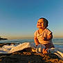 baby, infant, beach, ocean, pier, sunset, towel, sand, smiling, joy, sunlight, sky, horizon, seascape, barefoot, portrait, outdoor, cloudless, cute, summer