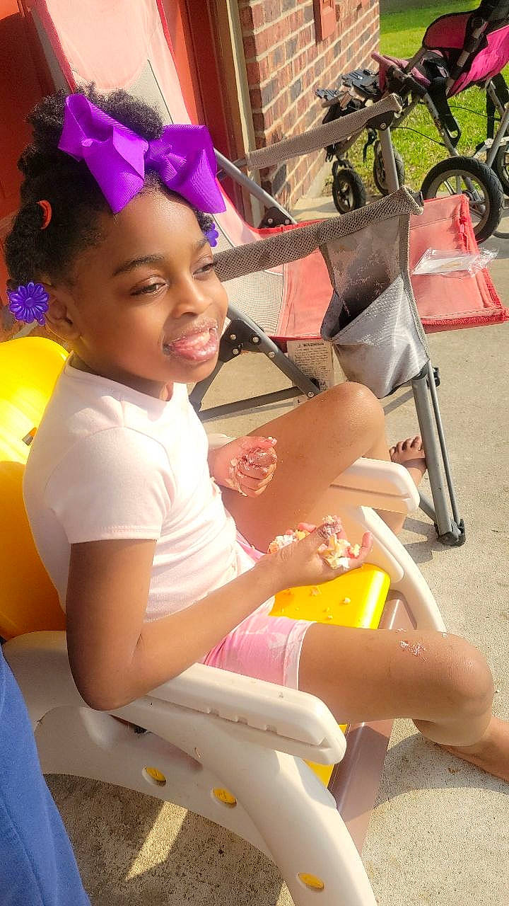 Alyssa joined the competition — help win amazing prizes! bicycle_wheel, black_hair, child, facial_expression, fun, happy, human_leg, leisure, long_hair, person, pink, recreation, sitting, skin, smile, summer, thigh, tire, wheel, white