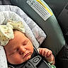 Fiona is registered to the contest to win money with this photo: baby, sleeping, car_seat, child, infant, face, bow, straps, clothing, headwear, safety, seatbelt, cute, peaceful, closeup, newborn, resting, soft_light, indoors, portrait