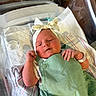 Fiona is registered to the contest to win money with this photo: newborn, baby, infant, hospital, bassinet, blanket, headband, clothing, person, resting, cute, sleepy, pink_cheeks, hospital_id_band, fabric, closeup, indoors, medical, soft_lighting, portrait