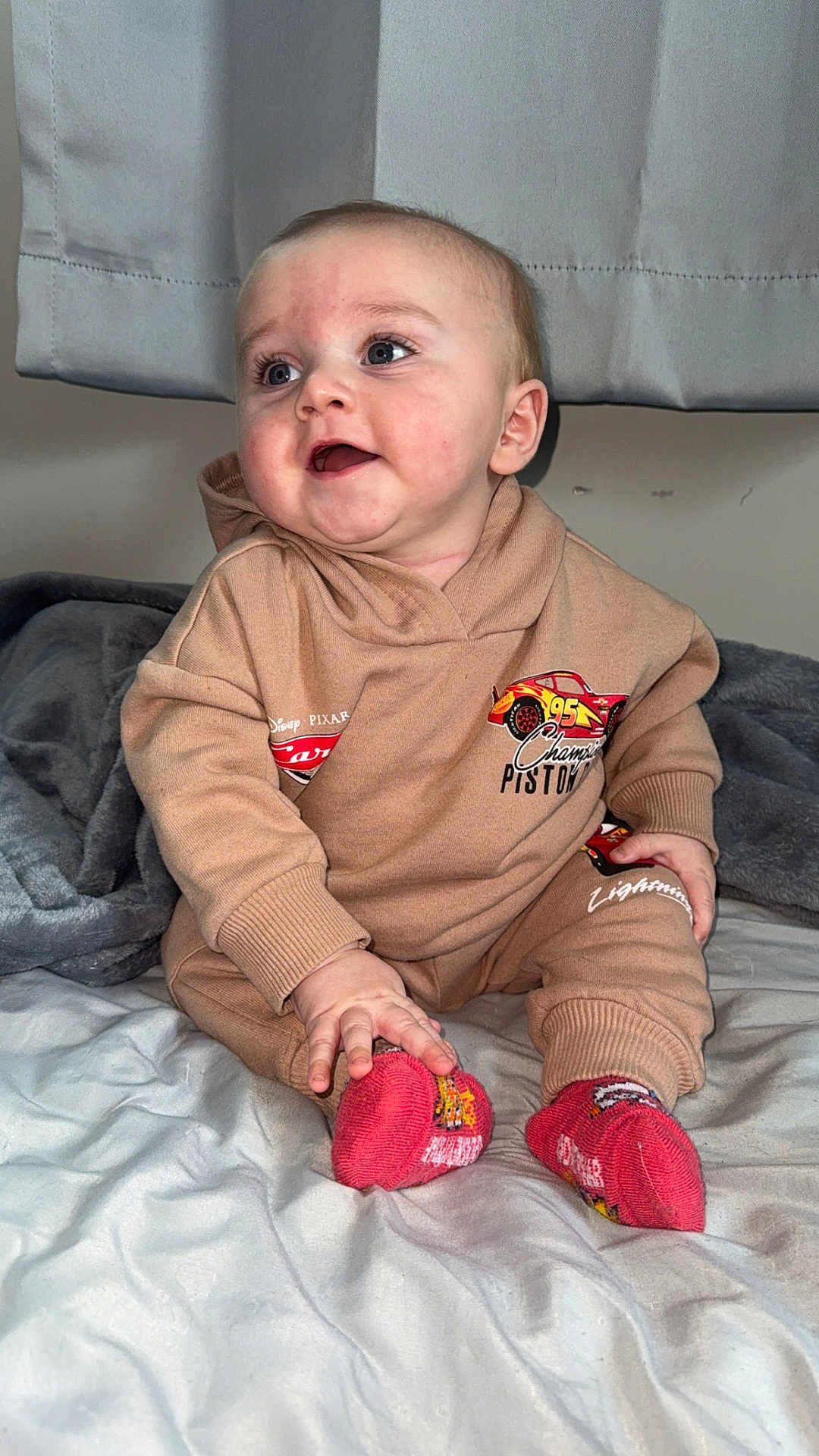 Roy joined the competition — help win amazing prizes! baby, infant, toddler, sitting, hoodie, socks, blanket, bed, curtain, blue_eyes, rosy_cheeks, smile, hand, cute, indoor, portrait, clothing, plush, happy, one_person