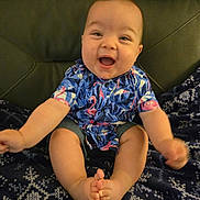 Thorne joined the competition — help win amazing prizes! baby, child, smiling, happy, sitting, shirt, flamingo, patterned_blanket, denim_shorts, feet, toes, indoor, furniture, couch, cute, portrait, infant, person, clothing, skin