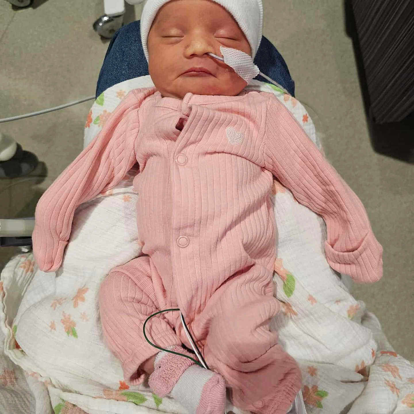 Briella joined the competition — help win amazing prizes! newborn, baby, infant, pink_onesie, white_hat, sleeping, nasal_tube, blanket, hospital, medical_equipment, person, child, indoors, resting, cute, small, cozy, wearing_clothes, healthcare, tender_moment