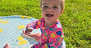 Leighton is registered to the contest to win money with this photo: backyard, child, colorful_clothing, dog, fun, grass, happy, inflatable_pool, outdoor, pet, play, pool, sitting, small_pool, smiling, summer, sunny, swimsuit, toddler, water