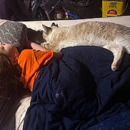 Ghosty joined the competition — help win amazing prizes! child, cat, sleeping, blanket, couch, pillow, orange_shirt, braided_hair, indoor, cozy, pet, resting, furniture, domestic, home, relaxation, animal, young_child, companion, casual