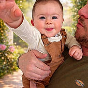 Gabin a rejoint le concours — aidez-le/la à gagner de superbes lots ! baby, child, person, adult, holding, smiling, happy, face, hand, outdoor, nature, flowers, bokeh, portrait, clothing, overalls, long_sleeve, beard, skin, casual