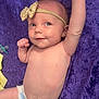 baby, infant, diaper, headband, bow, purple_blanket, pacifier, yellow_cloth, raising_arm, lying_down, cute, skin, smiling, child, newborn, portrait, one_person, indoors, happy, baby_girl