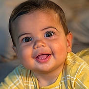 Kai is registered to the contest to win money with this photo: baby, smiling, face, child, yellow_clothing, portrait, closeup, happy, cute, infant, eyes, mouth, skin, person, indoors, soft_light, expression, young_child, head, baby_girl_or_boy