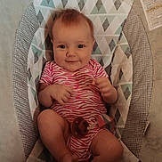 Aspen is registered to the contest to win money with this photo: baby, infant, smile, onesie, baby_rocker, patterned_fabric, geometric_pattern, indoor, child, cute, happy, person, seat, clothing, infant_clothing, small_person, baby_toy, pacifier, relaxing, young_child