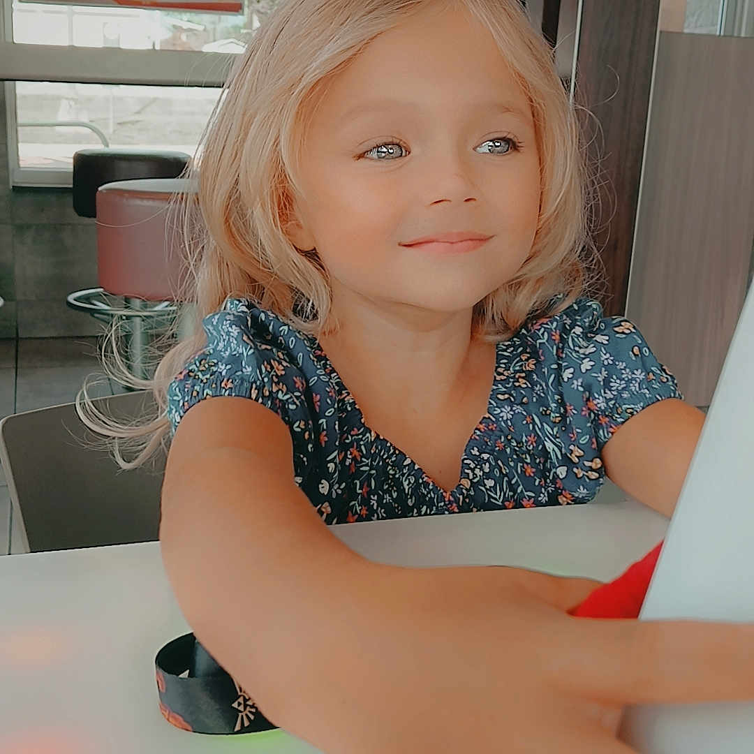 Athena is registered to the contest to win money with this photo: blonde, bodypart, burger, child, desk, face, female, finger, food, furniture, girl, hair, hand, head, indoors, interiordesign, person, restaurant, table, tape