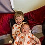 baby, blanket, child, clothing, couch, cozy, cute, family, happy, holding, home, indoor, pacifier, pajamas, portrait, pumpkin_pattern, red_cushions, seated, siblings, smiling