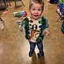 boy, child, classroom, colorful, festive, floor, furniture, hair, holiday, indoor, jeans, person, play, reindeer, shoes, sippy_cup, smiling, sweater, tinsel, toy