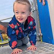 Theo joined the competition — help win amazing prizes! toddler, child, playground, climbing, jacket, dinosaur_pattern, outdoor, happy, smiling, hands, metal_surface, blue_sky, play_equipment, casual_clothing, short_hair, daylight, park, fun, cute, active