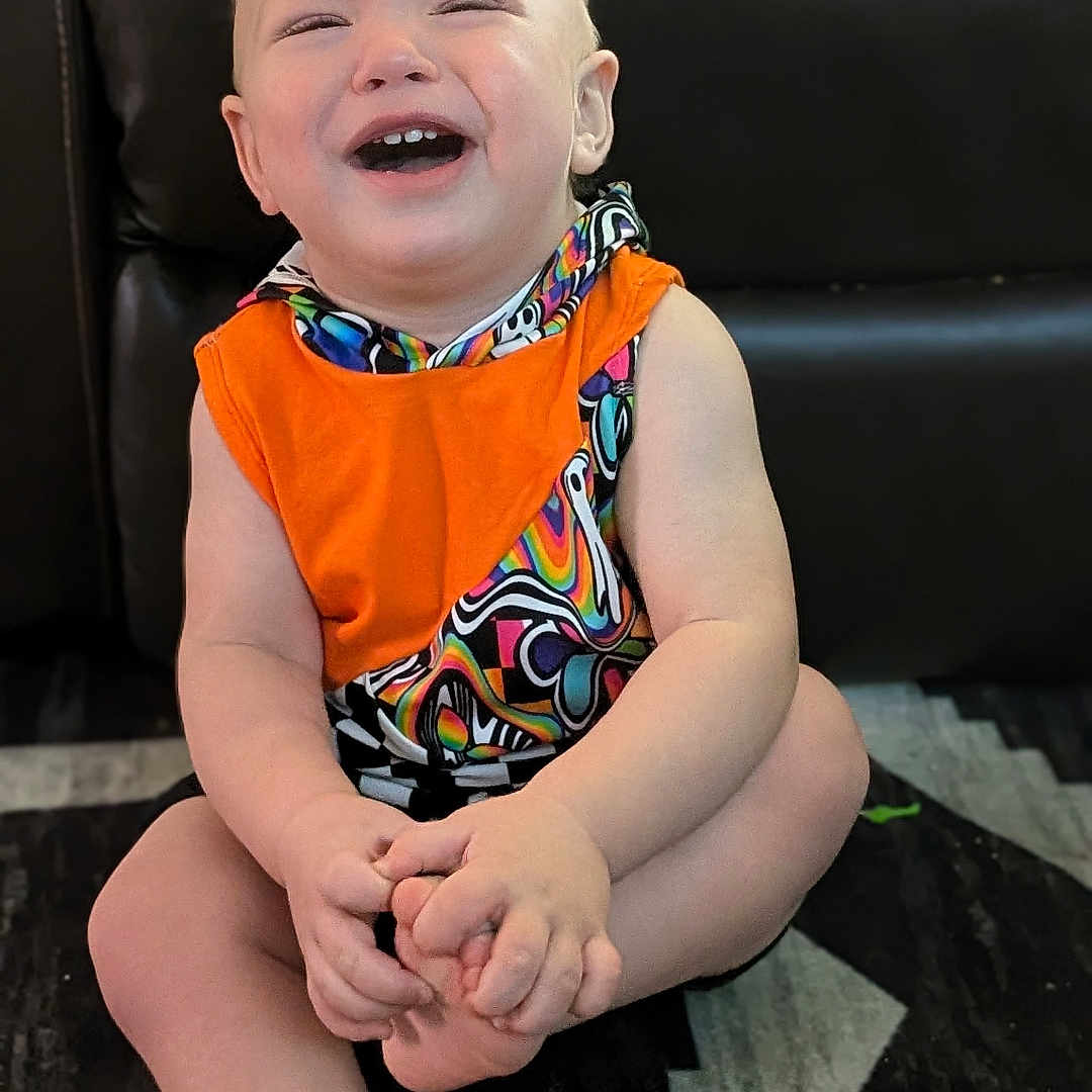 Huxley is registered to the contest to win money with this photo: accessories, baby, babylaughing, clothing, couch, dress, face, furniture, happy, head, homedecor, jewelry, laughing, necklace, person, photography, portrait, scarf, shorts, sitting