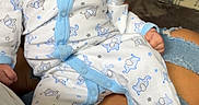 Kingston is registered to the contest to win money with this photo: baby, infant, pacifier, pajamas, hat, person, lap, ripped_jeans, blanket, laundry_basket, indoor, resting, cute, clothing, sleepwear, pattern, blue, white, human, comfort