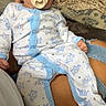 Kingston is registered to the contest to win money with this photo: baby, infant, pacifier, pajamas, hat, person, lap, ripped_jeans, blanket, laundry_basket, indoor, resting, cute, clothing, sleepwear, pattern, blue, white, human, comfort