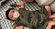 Kingston joined the competition — help win amazing prizes! baby, infant, pacifier, camo_clothing, mittens, black_hat, blanket, patterned_blanket, lying_down, arm, adult, resting, cute, infant_clothing, child, person, indoor, soft_fabric, comfort, close_up