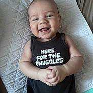 Jasper joined the competition — help win amazing prizes! apparel, baby, blanket, child, clothing, cute, face, hands, happy, indoor, infant, lying_down, onesie, person, portrait, quilted, skin, smiling, text_on_clothing, toddler