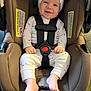 baby, baby_clothes, car_seat, child, child_seat, clothing, comfortable, cute, face, footwearless, happy, hat, headwear, indoor, infant, pajamas, safety_harness, seat_belt, small_person, smiling